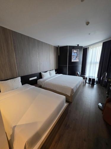 a hotel room with two beds and a window at Mandala Chambay Mũi Né - TAQ in Mui Ne