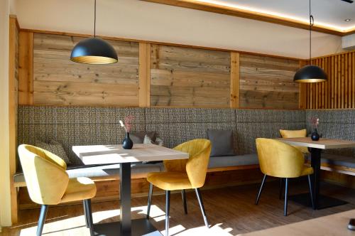 a restaurant with two tables and yellow chairs at Landhaus Riedl in Bad Füssing
