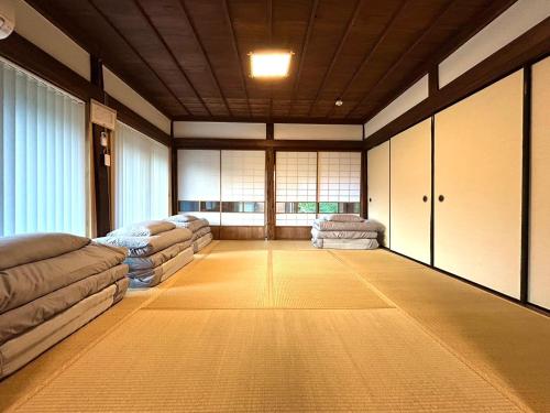 a living room with two couches and a room with windows at 古民家宿 Mutsu Traditional Japanese House Inn MUTSU in Ōtaki