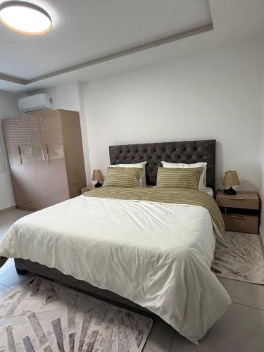 a bedroom with a large bed with a large white comforter at Sublime appartement F4 a draria in Alger