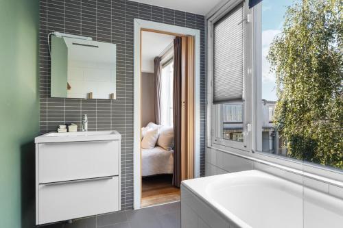 a bathroom with a sink and a mirror and a window at Bed zonder Breakfast in Amsterdam