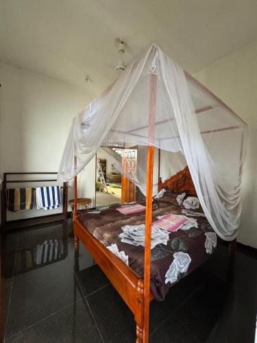 a bedroom with a bed with a mosquito net at Robbo's Surfcamp in Arugam Bay