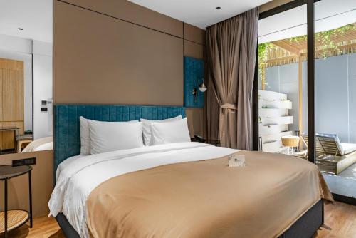 a bedroom with a large bed and a large window at GreenLa by Villacarte in Layan Beach