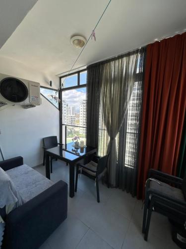 a living room with a table and a window at Pool View Studio Apartment Caesar Resort & Spa in Dherinia