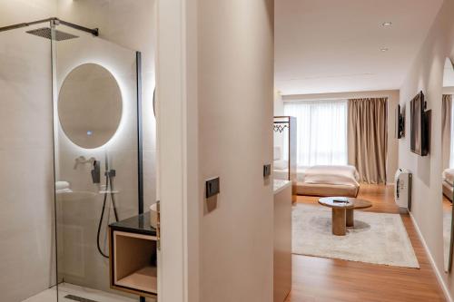 a bathroom with a shower and a living room at Agate Hotel Tirana in Tirana