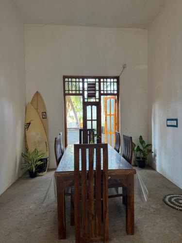 a dining room with a wooden table and chairs at Robbo's Surfcamp in Arugam Bay