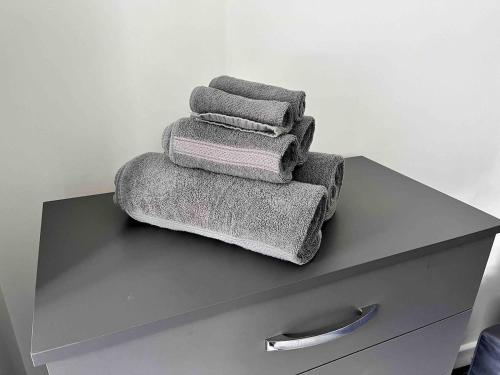 three towels are stacked on top of a dresser at The Limes! Flat 3 Private Studio Apartment in Quinton