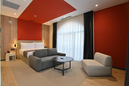 a bedroom with a bed and a couch and a chair at Mercure Tashkent North in Tashkent
