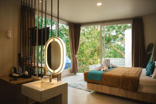 a bedroom with a bed and a mirror and a sink at HeHa Waterfall Suites & Camping Ground in Paragajen