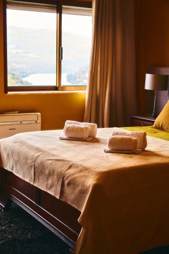 a bedroom with a bed with two towels on it at Douro Panorama Valley in Pinhão