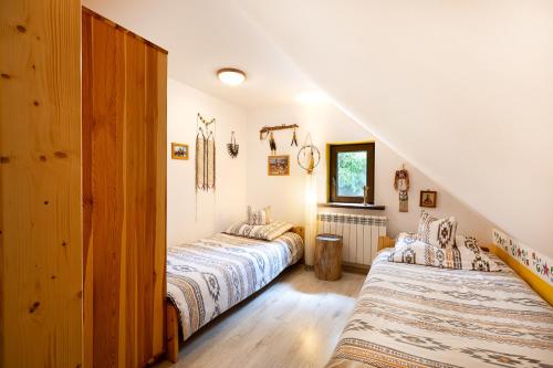 two beds in a room with a staircase at Agroturystyka na Podlasiu Kraina Puszczyka-Puszczykówka Biebrza, Augustów in Pokośno