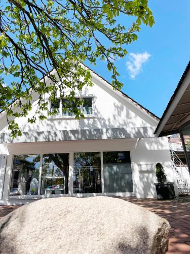 a white house with glass windows and a driveway at Ferienwohnung Anni in Schneverdingen