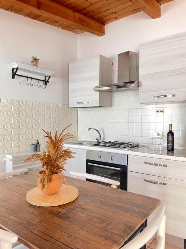 a kitchen with a wooden table with a plant on it at DomuMnG in Elmas