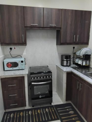 a kitchen with a stove and a microwave at Achievers stays in Kitengela 