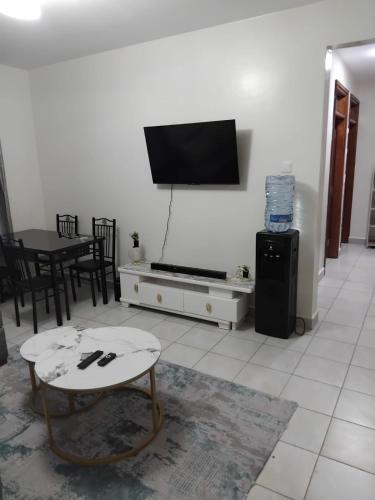 a living room with a flat screen tv on a wall at Achievers stays in Kitengela 