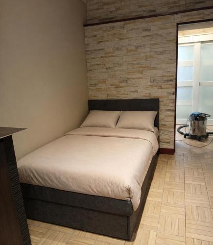 a bed in a room with a brick wall at Miczurina in Wałbrzych