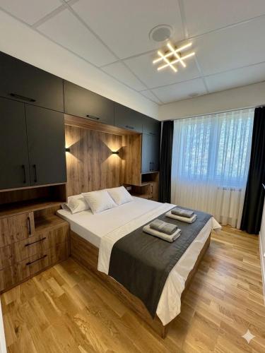 a bedroom with a large bed with two towels on it at Emerald Luxury Apartments in Skopje