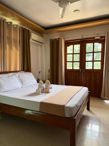 a bedroom with a large bed with two stuffed animals on it at Buena's Haven Travelodge in El Nido