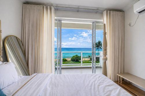 a bedroom with a bed and a view of the ocean at Anarma Oceanfront Apartment in Wattala