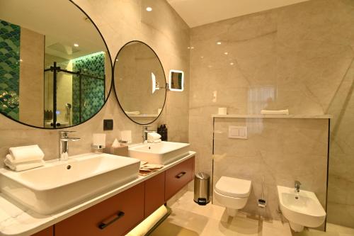 a bathroom with a sink and a toilet and a mirror at Mercure Tashkent North in Tashkent