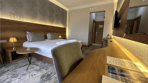 a hotel room with a bed and a table at Yoncalı Termal Spa Otel in Ortaca