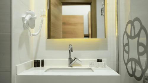 a bathroom with a white sink and a mirror at Yoncalı Termal Spa Otel in Ortaca