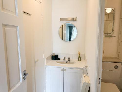 a white bathroom with a sink and a mirror at Princess House in Redhill