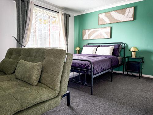 a bedroom with a bed and a couch next to a window at Princess House in Redhill