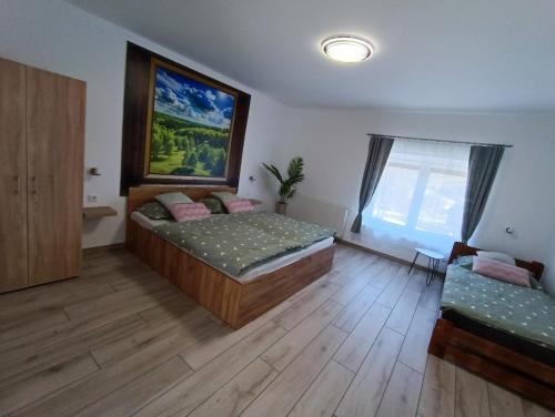 a bedroom with two beds and a window at Bakony Kincse Vendégház in Jásd