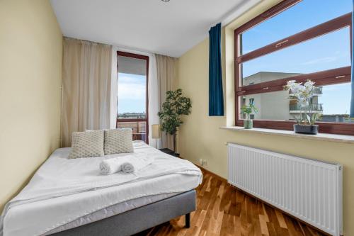 a bedroom with a bed and a large window at Spacious 3Rooms Apt with Balcony Parking in Warsaw