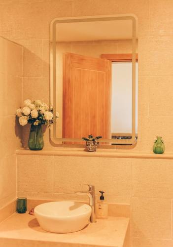 a bathroom sink with a mirror and a vase of flowers at Green studio in Dahab in Dahab