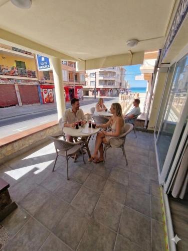 a group of people sitting at a table on a patio at Hostal Sol de Mallorca in El Arenal