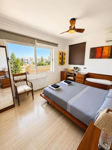 a bedroom with a bed and a chair and a window at Villa Filipinas ,CITY CENTER -ETV10310 in Palma de Mallorca