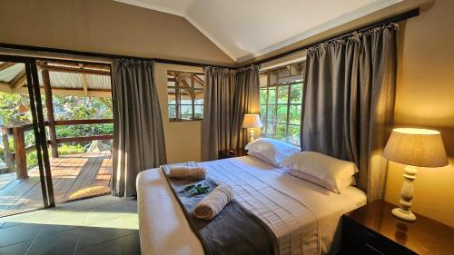 a bedroom with a bed and a large window at Lidwala Lodge in Ezulwini