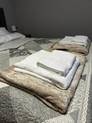 a pile of towels sitting on top of a bed at Hello Tu Modlin in Zakroczym