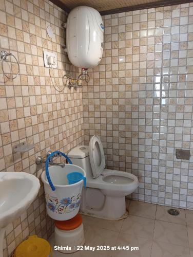 a bathroom with a toilet and a sink at New Malook hotel in Shimla