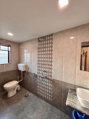 a bathroom with a toilet and a sink at Crescent Holiday Homes in Panchgani