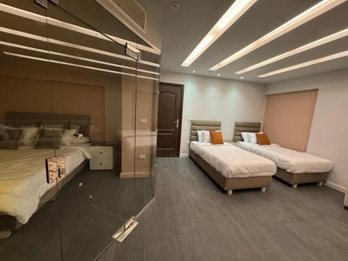 a hotel room with two beds and a mirror at The Perfect in Alexandria