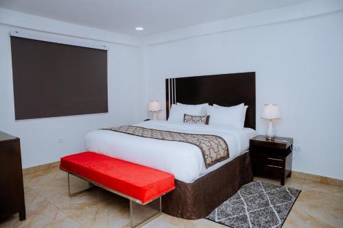 ein Schlafzimmer mit einem großen Bett und einer roten Bank in der Unterkunft Sinkor Palace Hotel in Monrovia