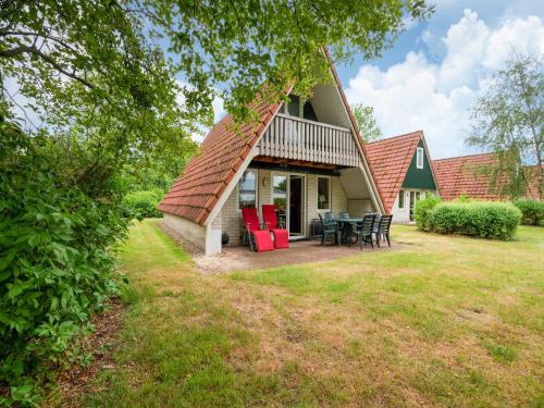 a house with a thatched roof and a patio at Holiday home in Gramsbergen in Gramsbergen