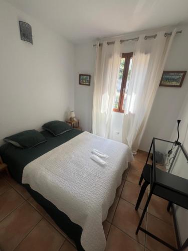 a bedroom with a white bed and a window at La Panouse in Marseille