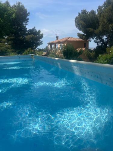 a swimming pool with blue water in front of a house at La Panouse in Marseille