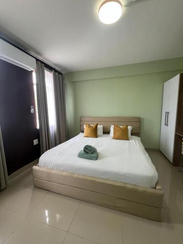a bedroom with a bed with white sheets and yellow pillows at 112 On Park Drive in Gqeberha