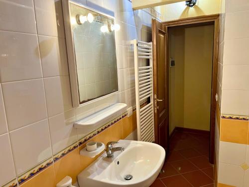 a bathroom with a sink and a mirror at Nido in Toscana - Appartamento in Centro Storico con Aria Condizionata in Buonconvento