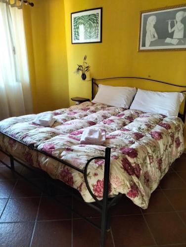 a large bed in a bedroom with a bedspread on it at Appartamento Rosa in Montale