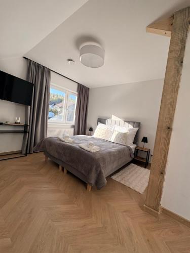 a bedroom with a large bed and a large window at Willa Nowa 33 in Wisła