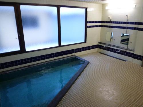 bagno con piscina e finestre di ビューリゾートインとみや a Yuzawa