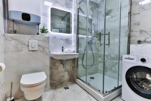 a bathroom with a shower and a toilet and a sink at Numa by Kraft in Podgorica