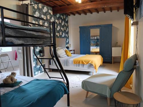 a bedroom with two bunk beds and a chair at La salamandre de l'escat chambres et table d'hôtes in Montastruc-de-Salies