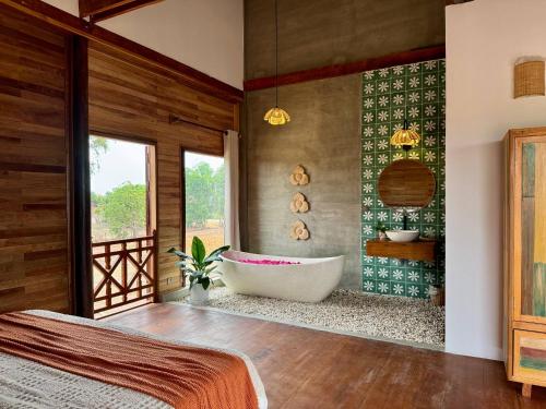 a bedroom with a bath tub and a window at Dontrei Villa Angkor in Siem Reap